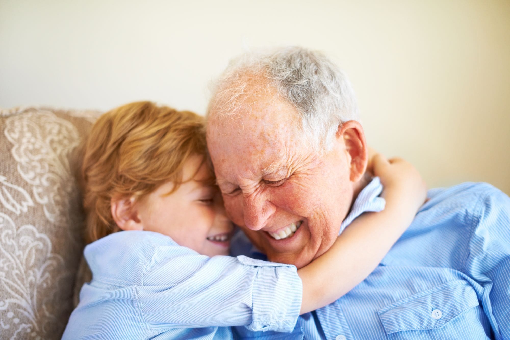 Young boy gives hug around the neck to Flourish Senior Living memory care resident