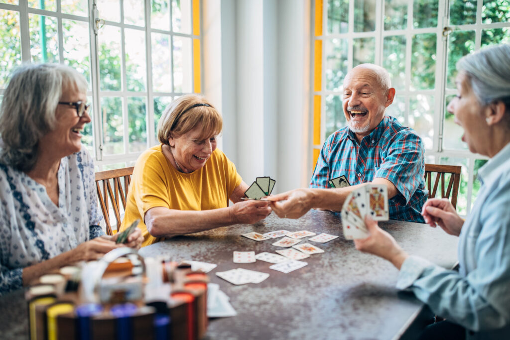 Seniors playing card game around a table